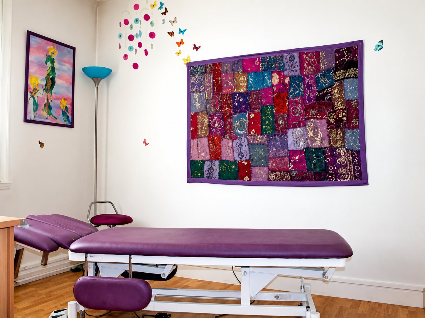 Cabinet d’ostéopathie à Sartrouville : table de soin violette et tissu patchwork au mur